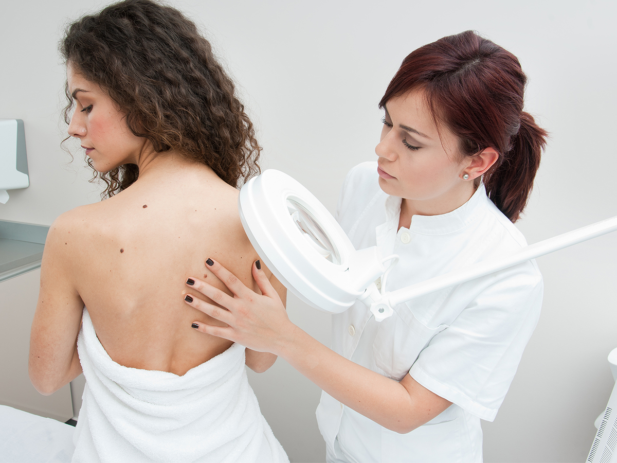 Dermatologist checking woman's skin