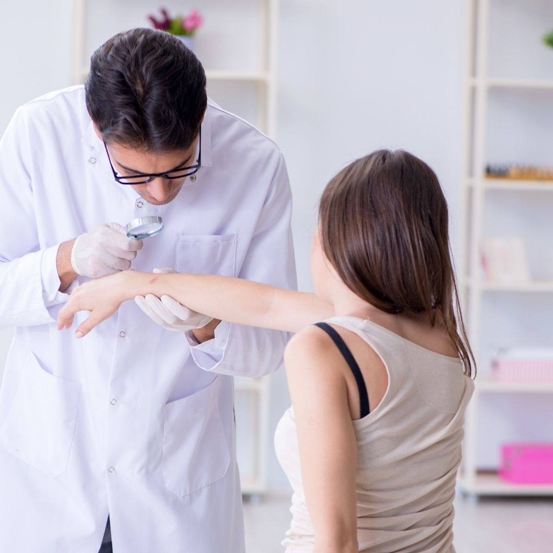 doctor examining woman's arm