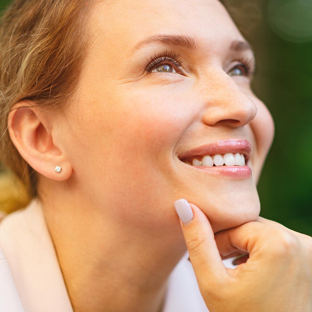 smiling woman with her hand on her chin