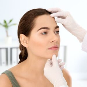 dermatologist looking at woman's face