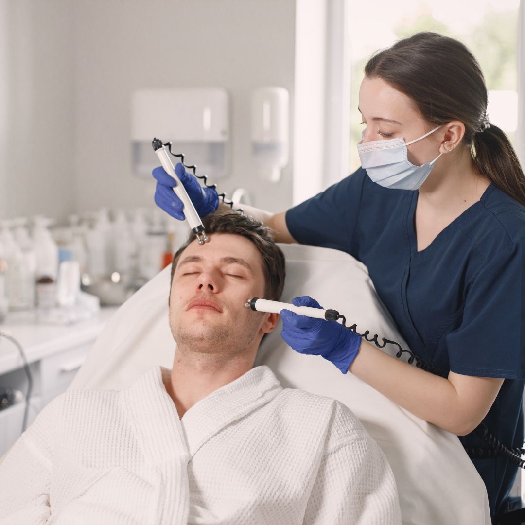 Healthcare worker in mask using instruments on a mans facial skin