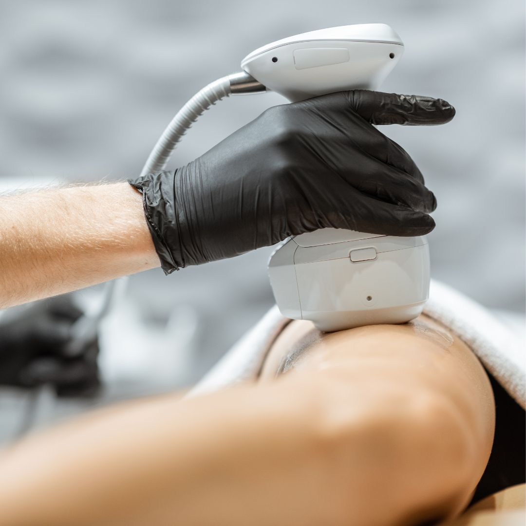 Gloved hand holding medical instrument onto a leg