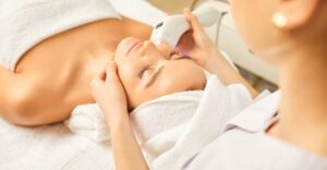 woman laying on a treatment table receiving a facial skin treatment