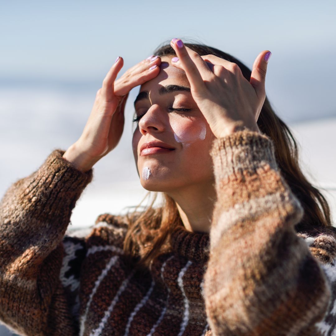 woman applying sunscreen to her face