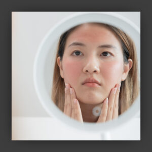 Woman looking in the mirror at her clear skin