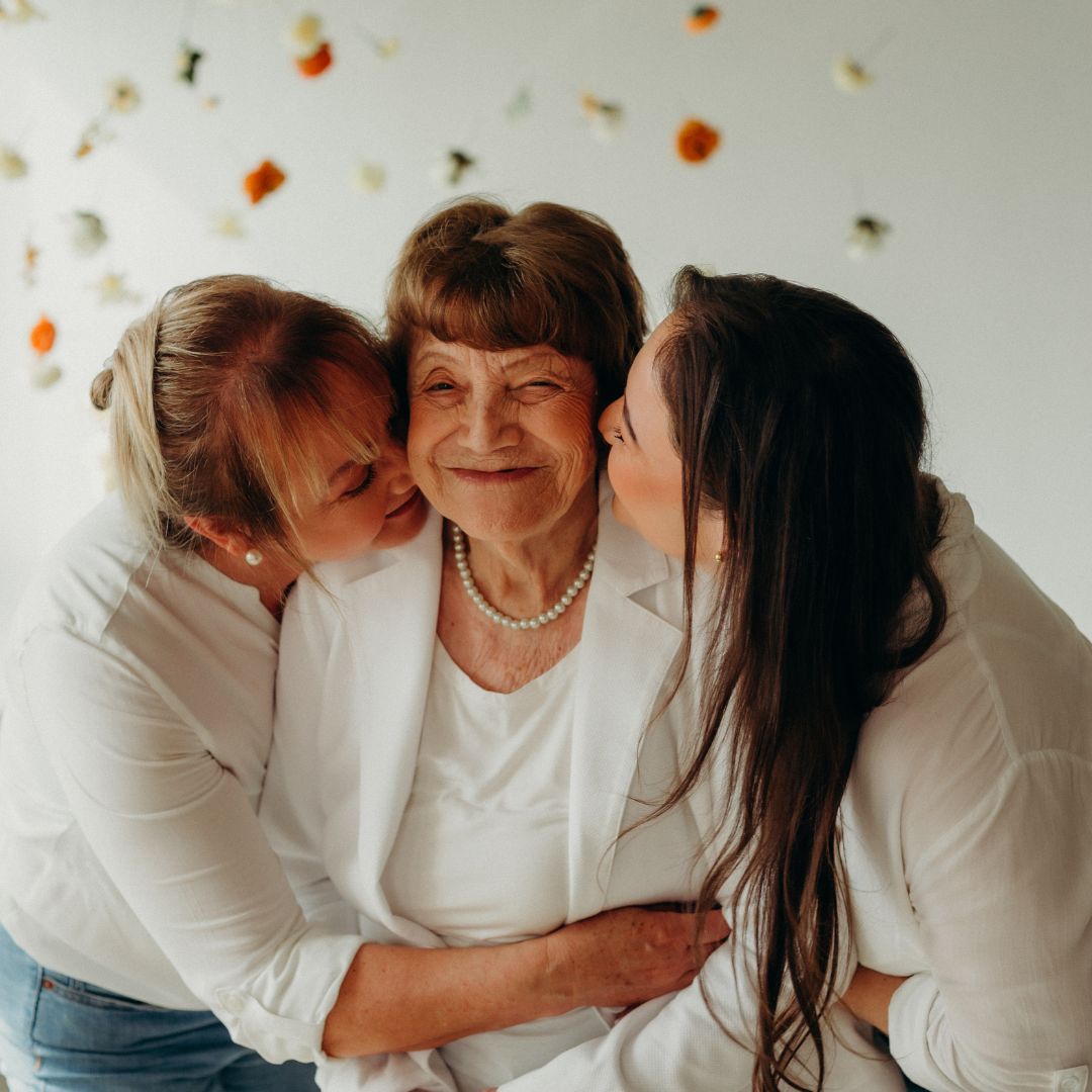 Mother and Daughter giving grandma a kiss on the cheek
