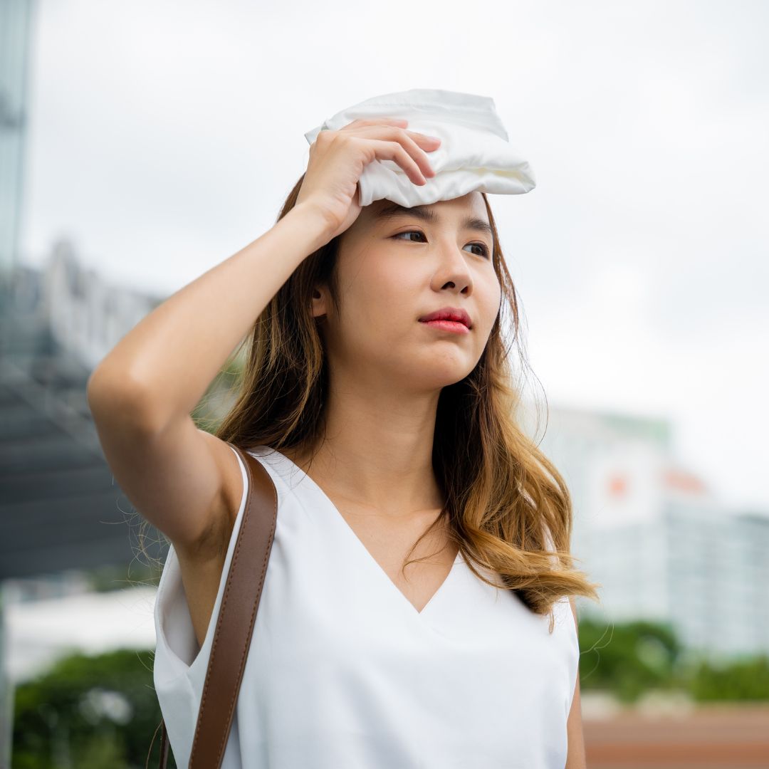 A women holding a towel to her forehead