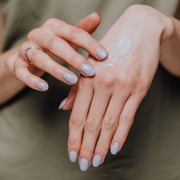 applying sunscreen to back of hand